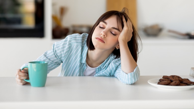 Tired young woman at kitchen counter