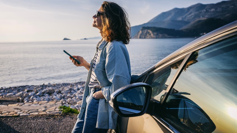 Woman standing by car