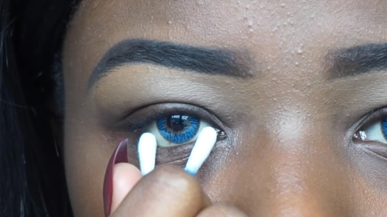 Woman removing contact lenses with