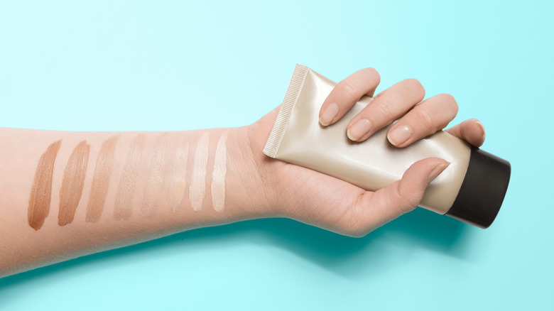 A woman holding a tinted moisturizer 