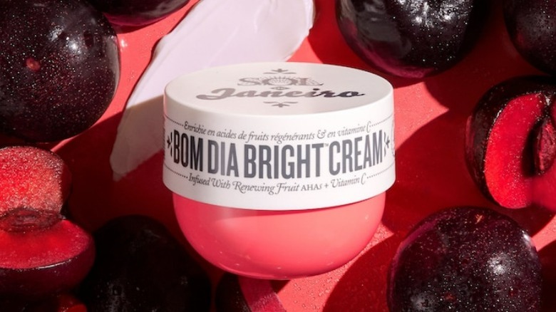 Body cream surrounded by plums