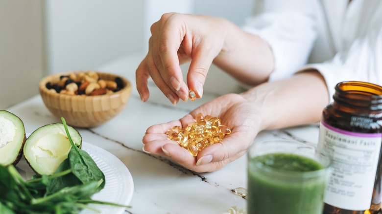 Hand holding vitamin d capsules 