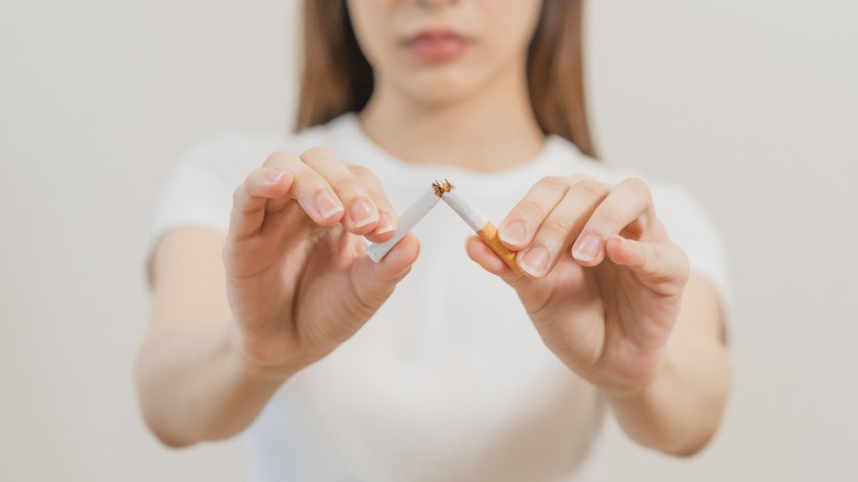 Woman breaking a cigarette 