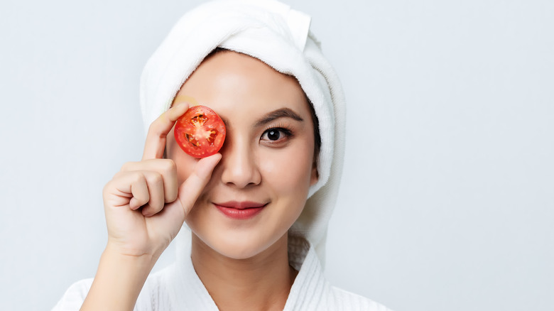 Woman holding a tomato for a facial mask