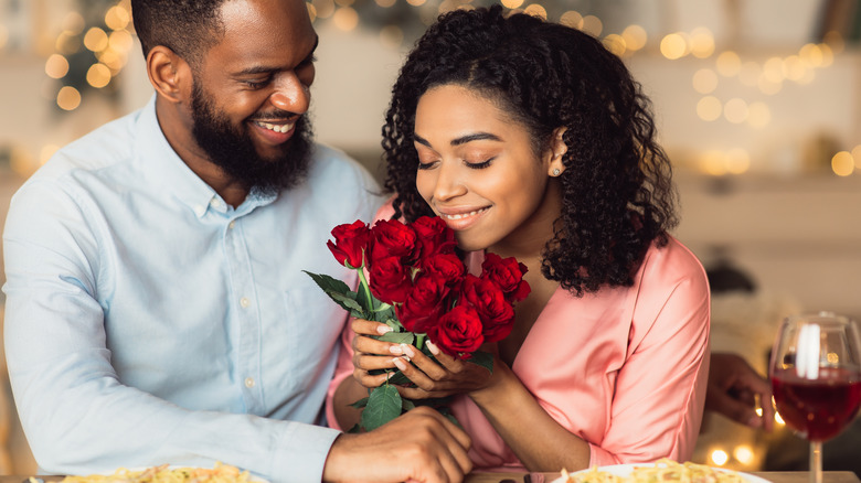 Person smelling bouquet of roses