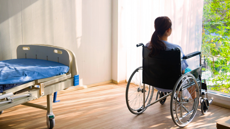 Woman in wheelchair looking out window