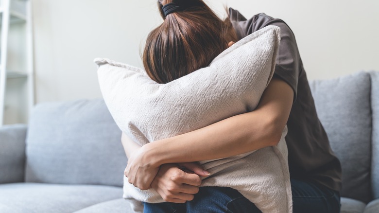 Anxious woman holding a pillow 