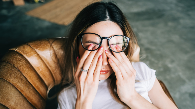 A woman rubbing her eyes