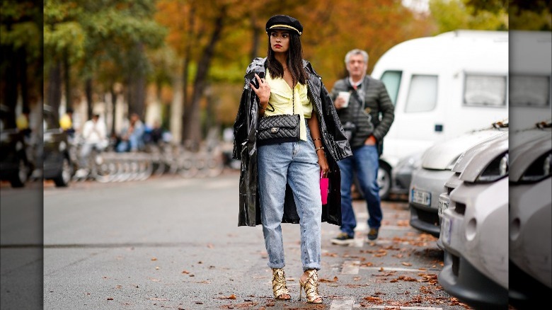 Person in gold sandals and trench coat