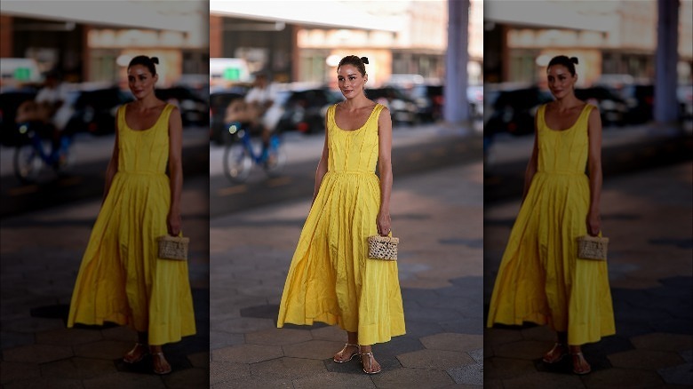Person in yellow sundress and gold sandals