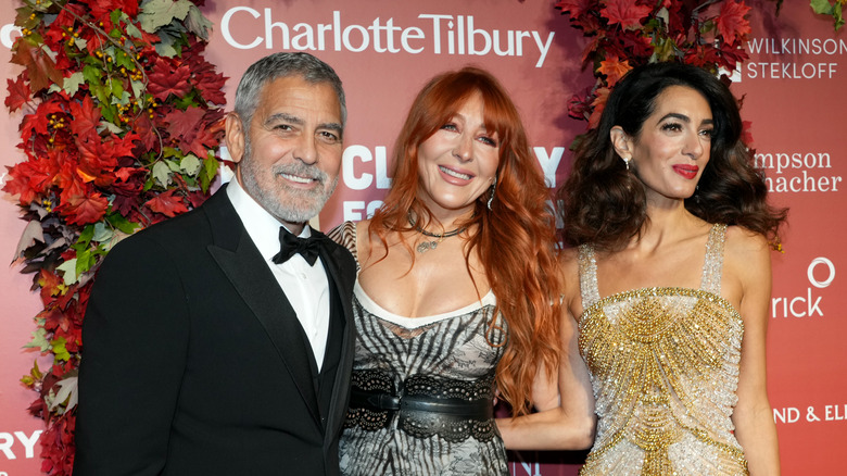 George Clooney and Charlotte Tilbury and Amal Clooney smiling 