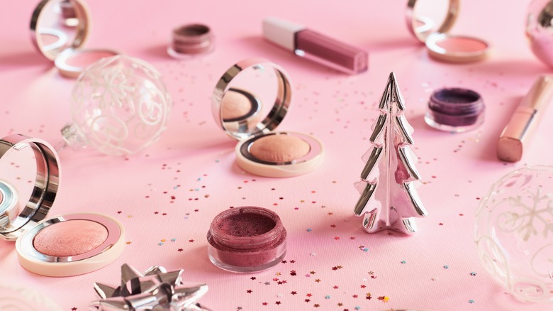 Holiday makeup arranged amid confetti and ornaments