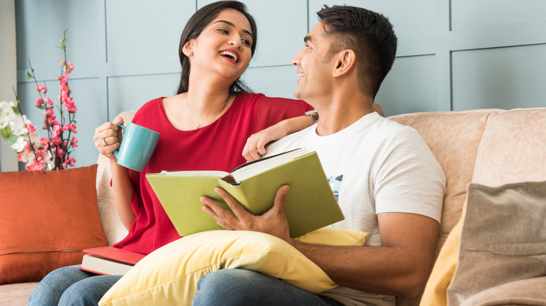 smiling couple looking at book