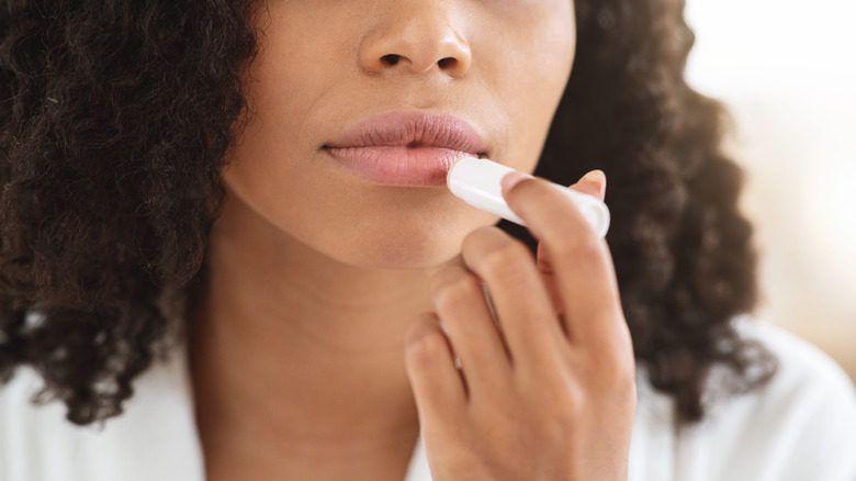 Woman applying lip balm