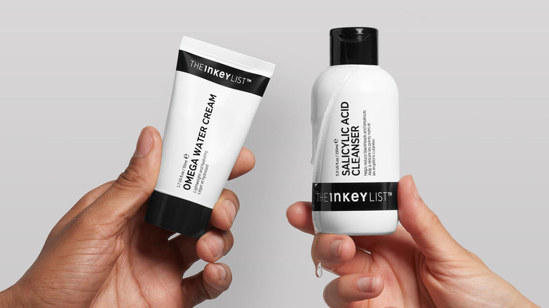 Hands holding The Inkey List products