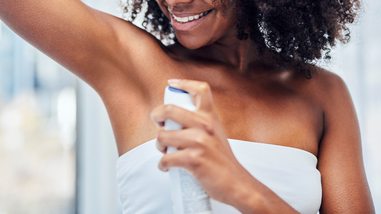 woman spraying deodorant