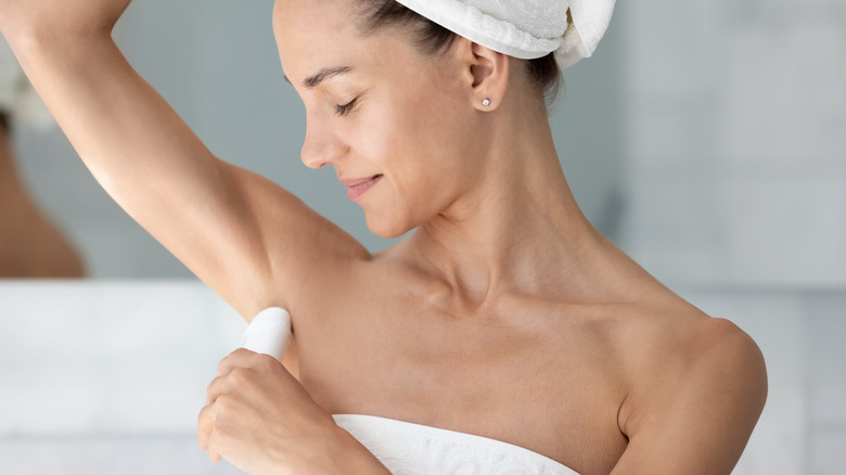 woman applying deodorant
