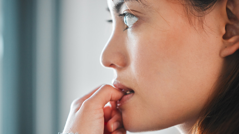 young woman biting nails