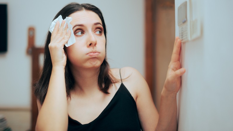 tense woman dabs forehead with tissue