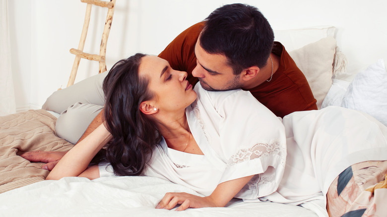 couple getting ready to kiss in bed