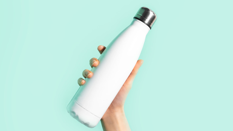 hand holding white water bottle