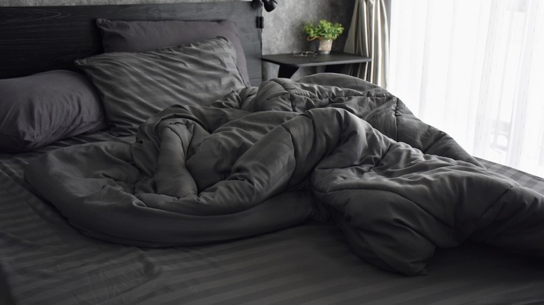 messy bed with grey bedding