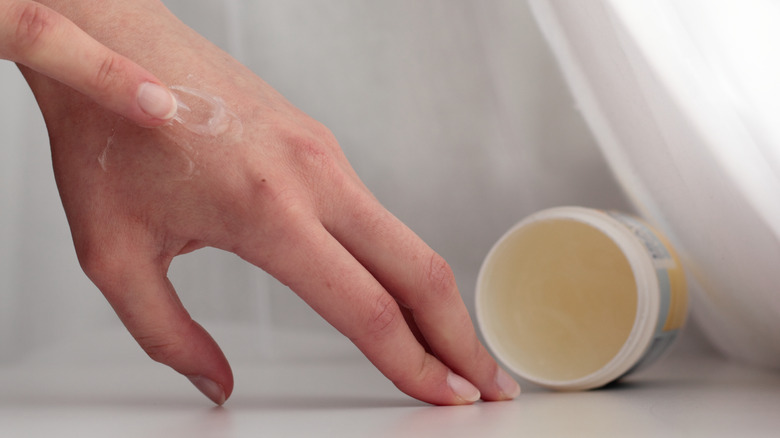 applying petroleum jelly to hand