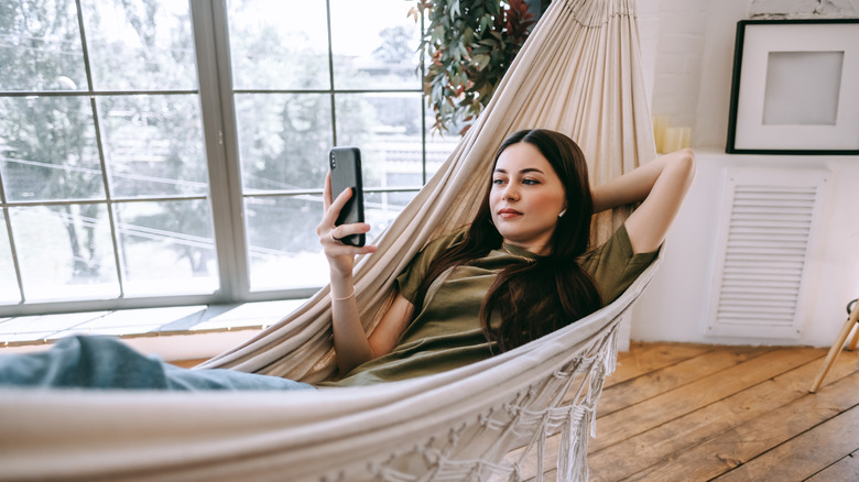 woman texting in hammock