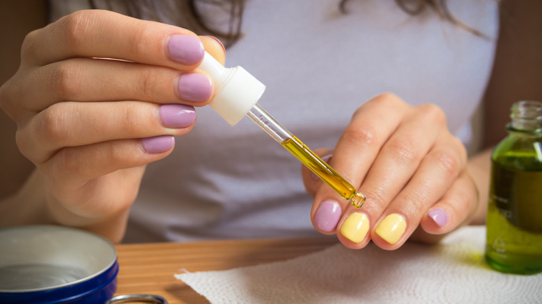 Woman applying oil to nails