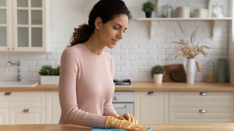 Woman wearing gloves while cleaning