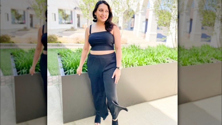 Woman wearing black crop top, pants