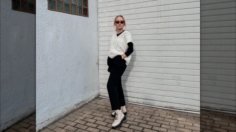 Sweater vest over a black long-sleeve shirt