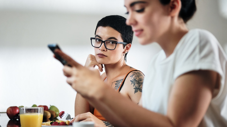 Woman on phone ignoring friend 