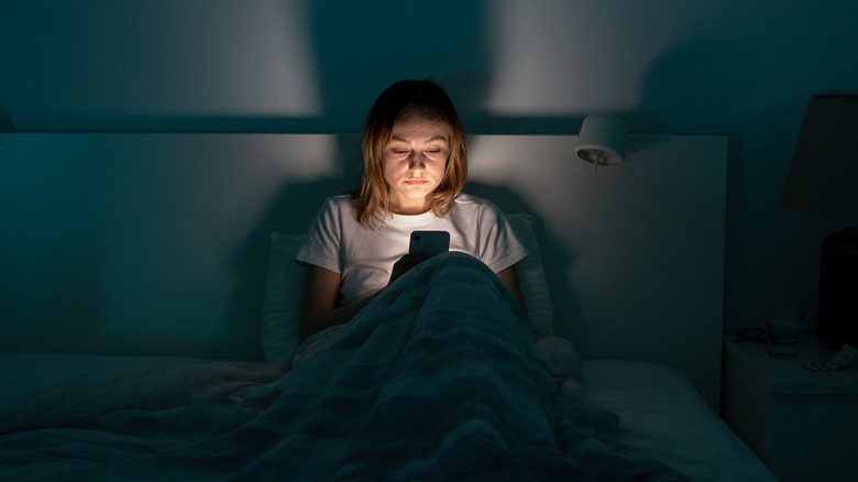 woman in dark room on phone 