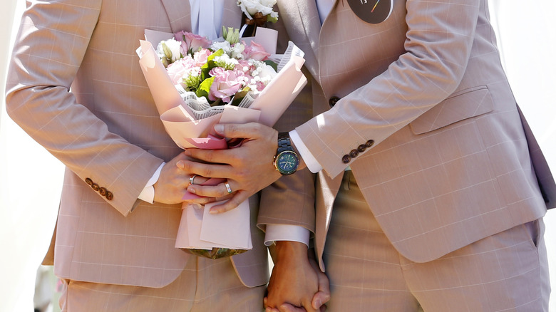 Same sex couple holding bouquet 