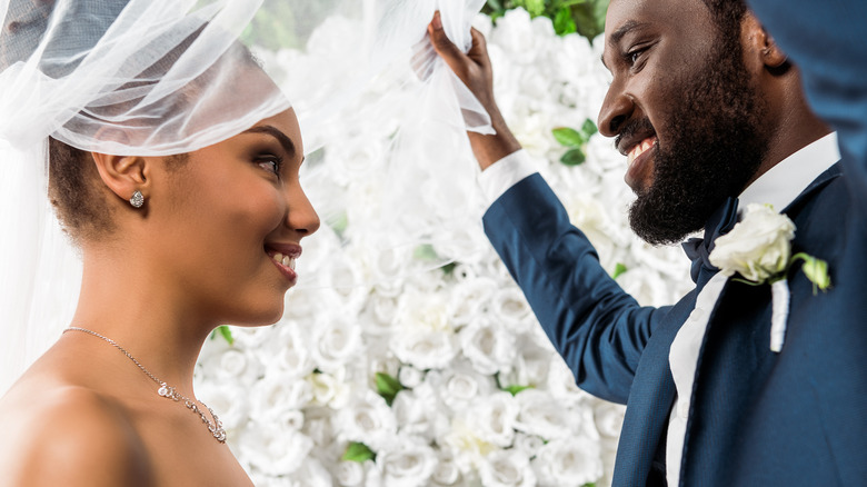 Groom lifting the veil off his bride 