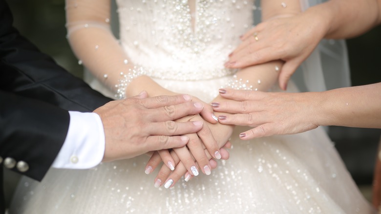 Bride's parents holding her hands 