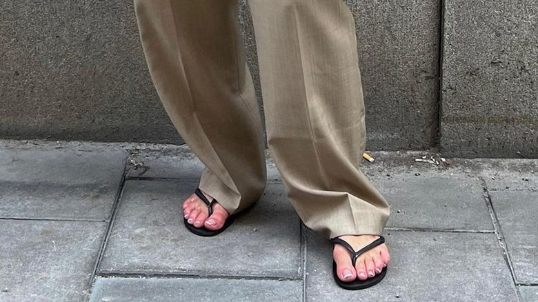 Person with beige pants and French pedicure