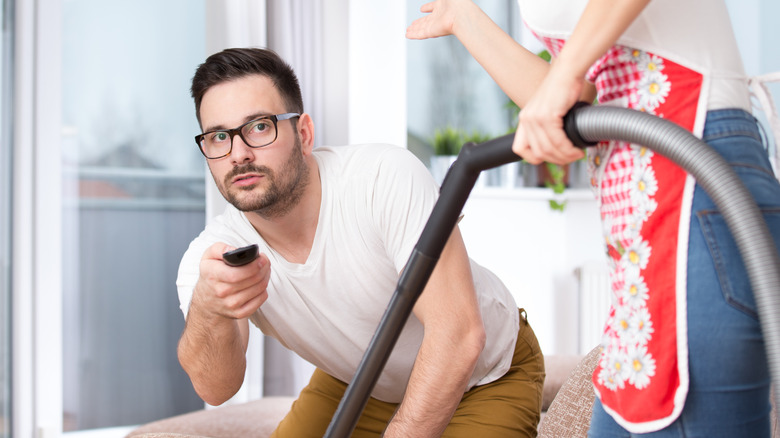 woman cleaning man with remote