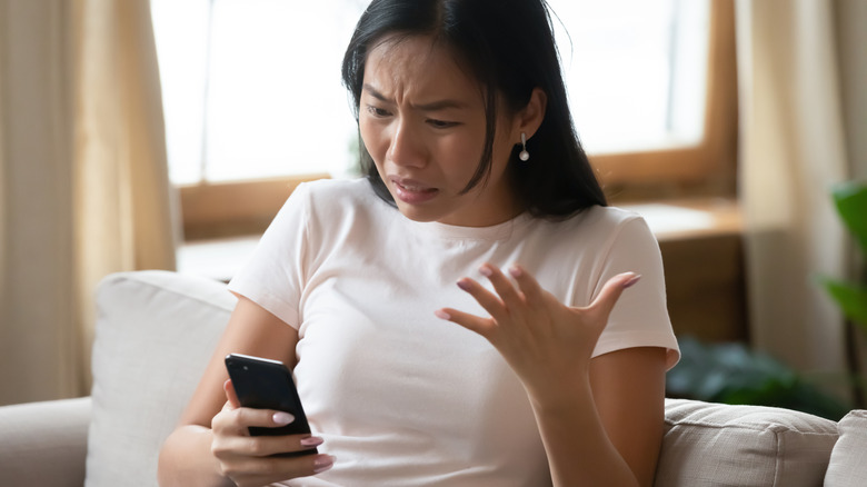 angry woman looking at her phone