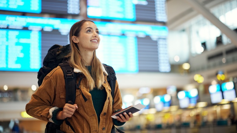 A woman carrying a backpack in an airport