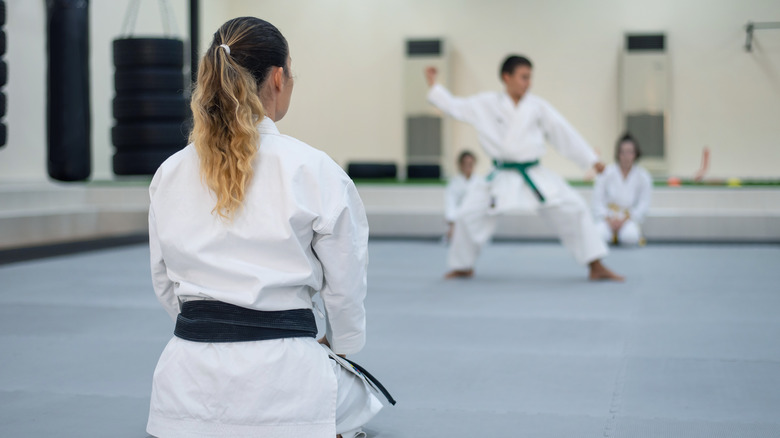 A woman watching someone perform martial arts