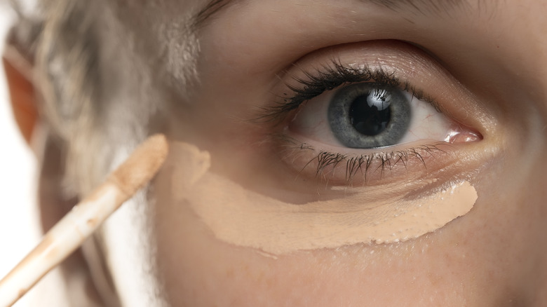 Woman using heavy concealer