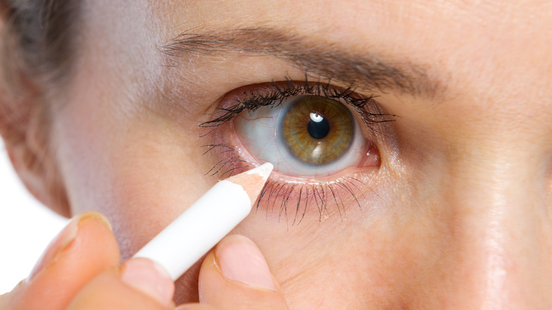 Woman using white eyeliner