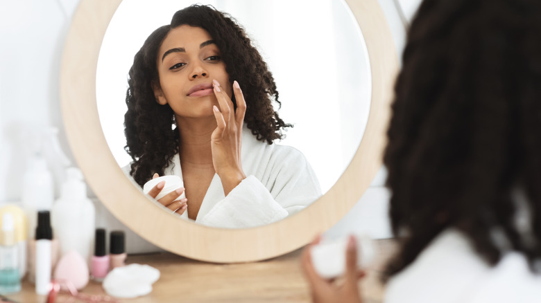 A woman applying lip cream