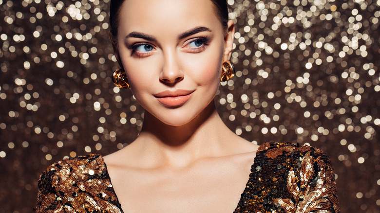 woman smirking with sparkle background