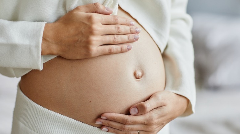 Pregnant woman holding belly