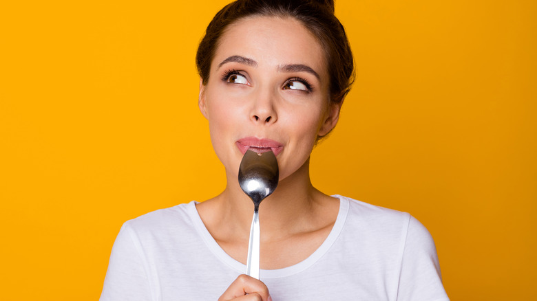 Woman smiling and holding a spoon