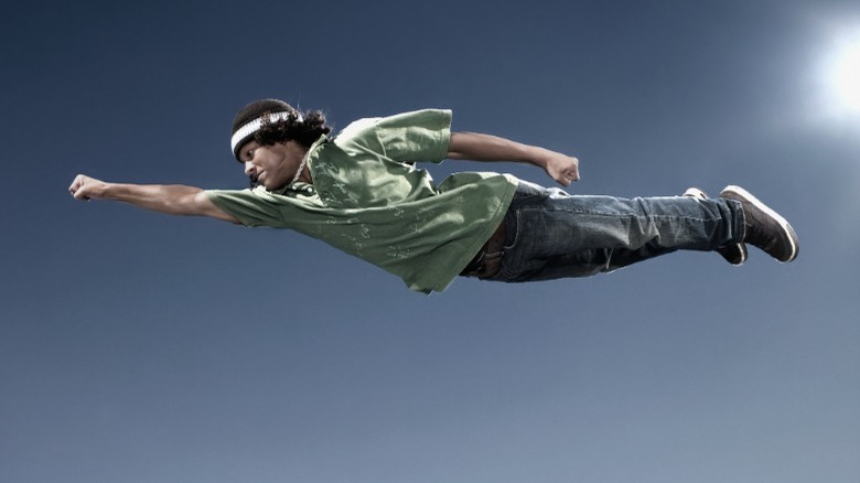 Young man flying through sky