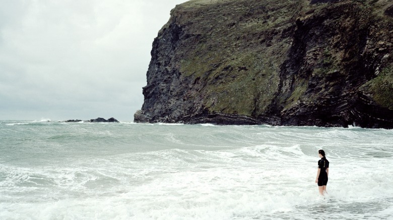 Woman walking in ocean waves